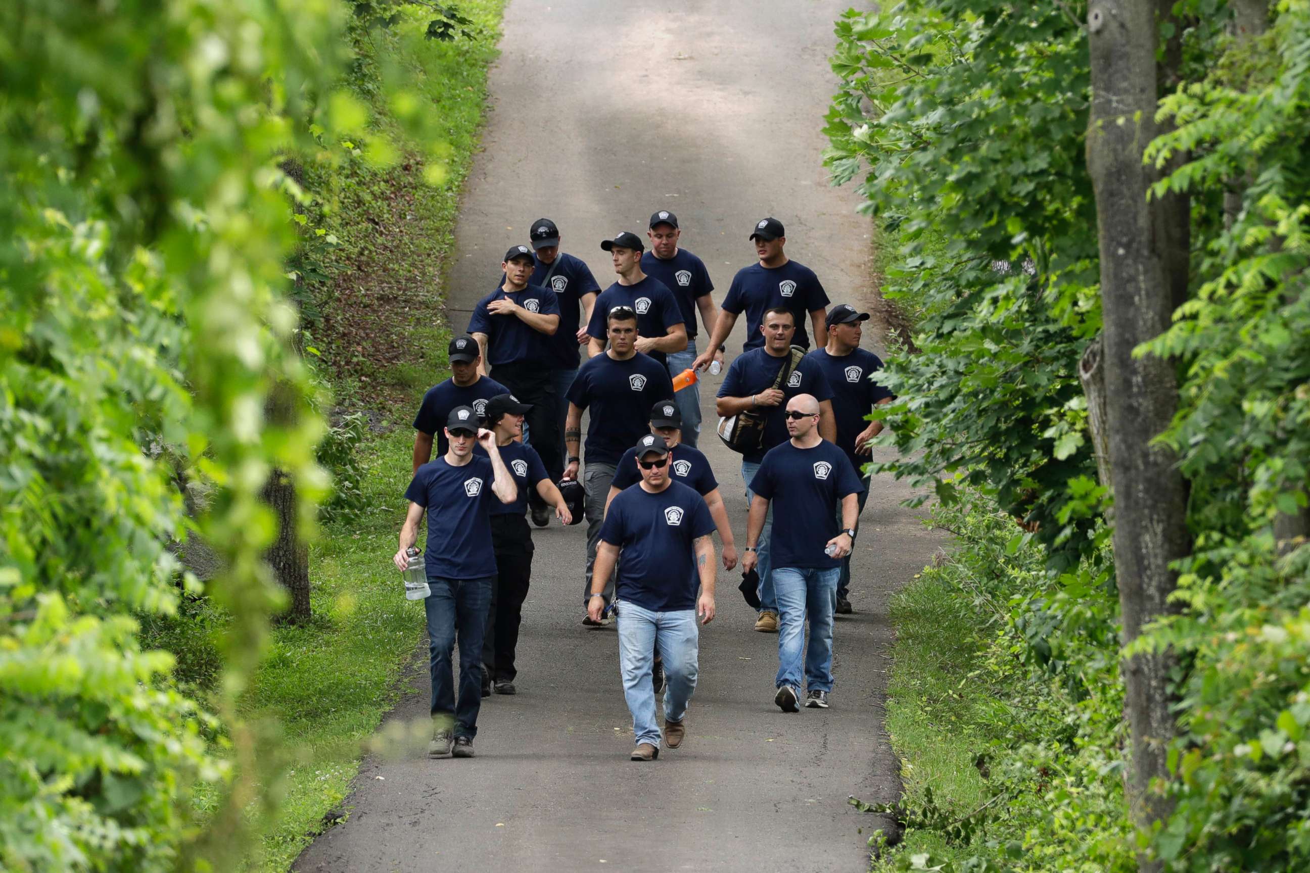 PHOTO: Law enforcement workers walk down a blocked off drive way in Solebury, Pa., as the search resumes Tuesday, July 11, 2017, for four missing young Pennsylvania men.