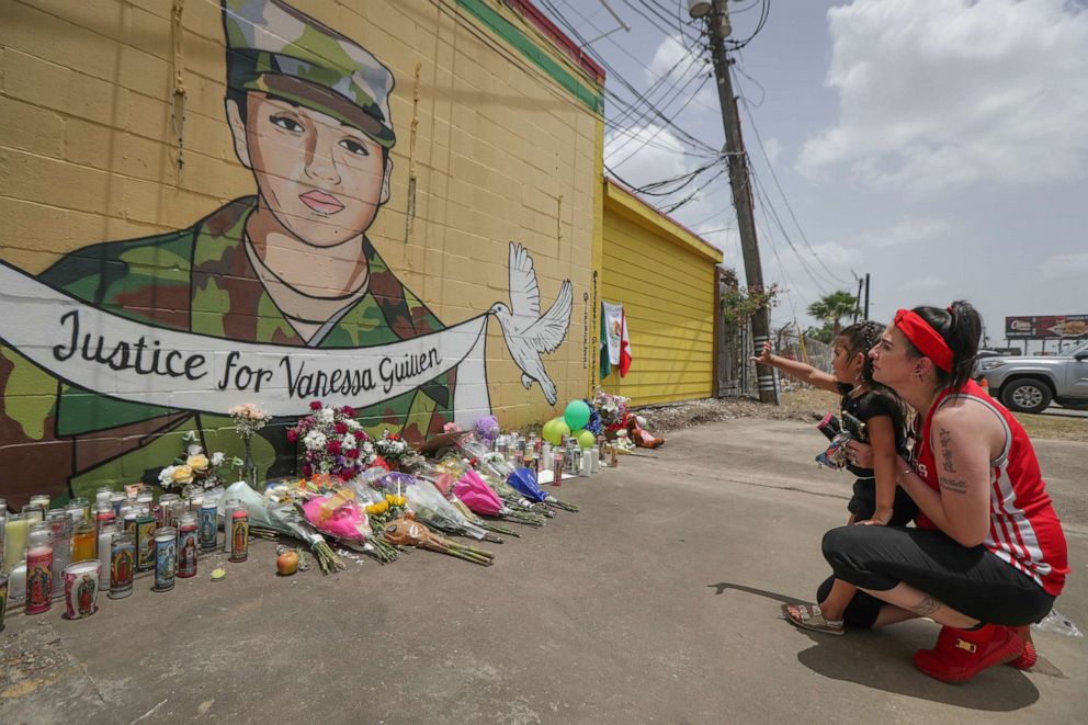 PHOTO:Dawn Gomez holds her 3-year-old granddaughter, Saryia Greer, who waves at Vanessa Guillen's mural painted by Alejandro "Donkeeboy" Roman Jr. on the side of Taqueria Del Sol, July 2, 2020, in Houston.