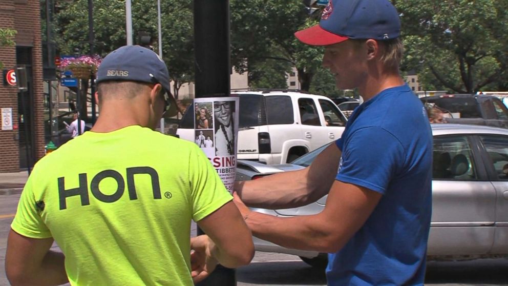 PHOTO: Men post a missing person flyer in Brooklyn, Iowa, in the search for Mollie Tibbetts. 