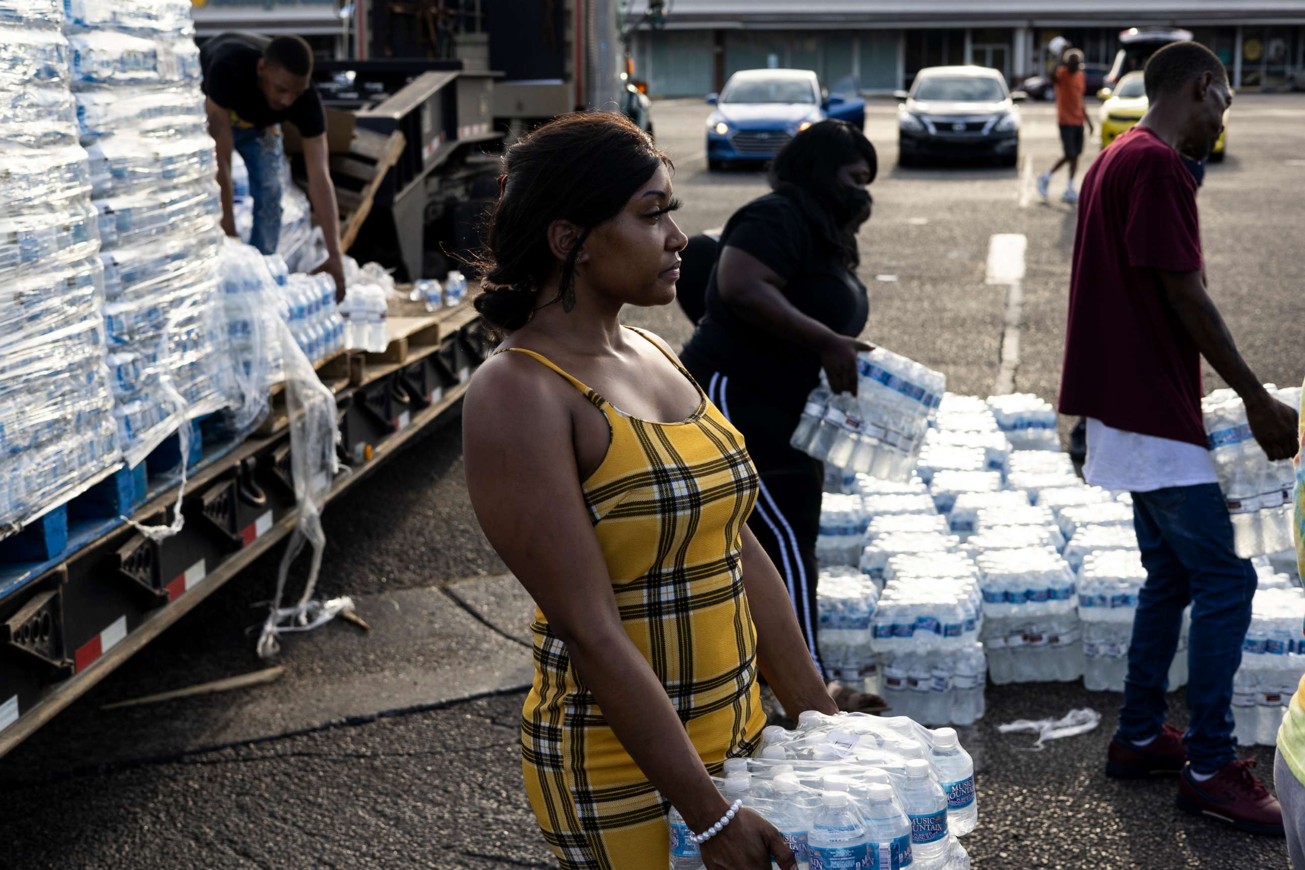 PHOTO: Aelicia Hodge (C) helps hand out cases of bottled water at a Mississippi Rapid Response Coalition distribution site, Aug. 31, 2022, in Jackson, Miss. 