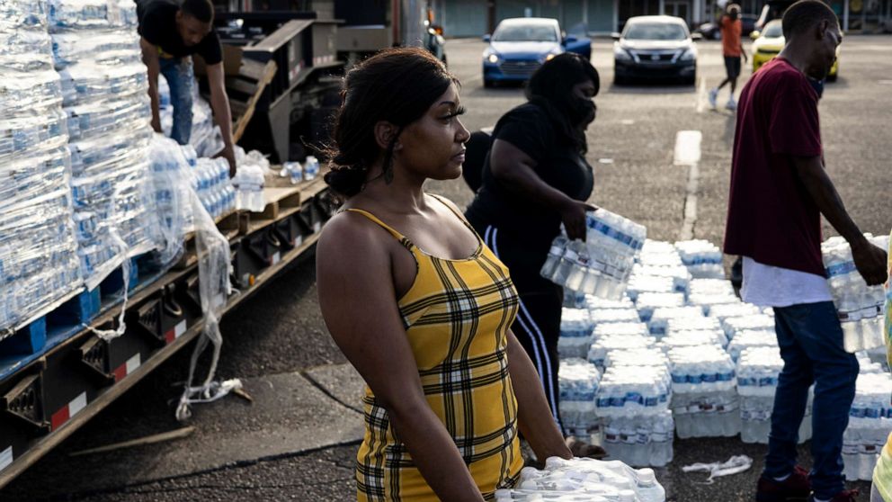 PHOTO: Aelicia Hodge (C) helps hand out cases of bottled water at a Mississippi Rapid Response Coalition distribution site, Aug. 31, 2022, in Jackson, Miss. 