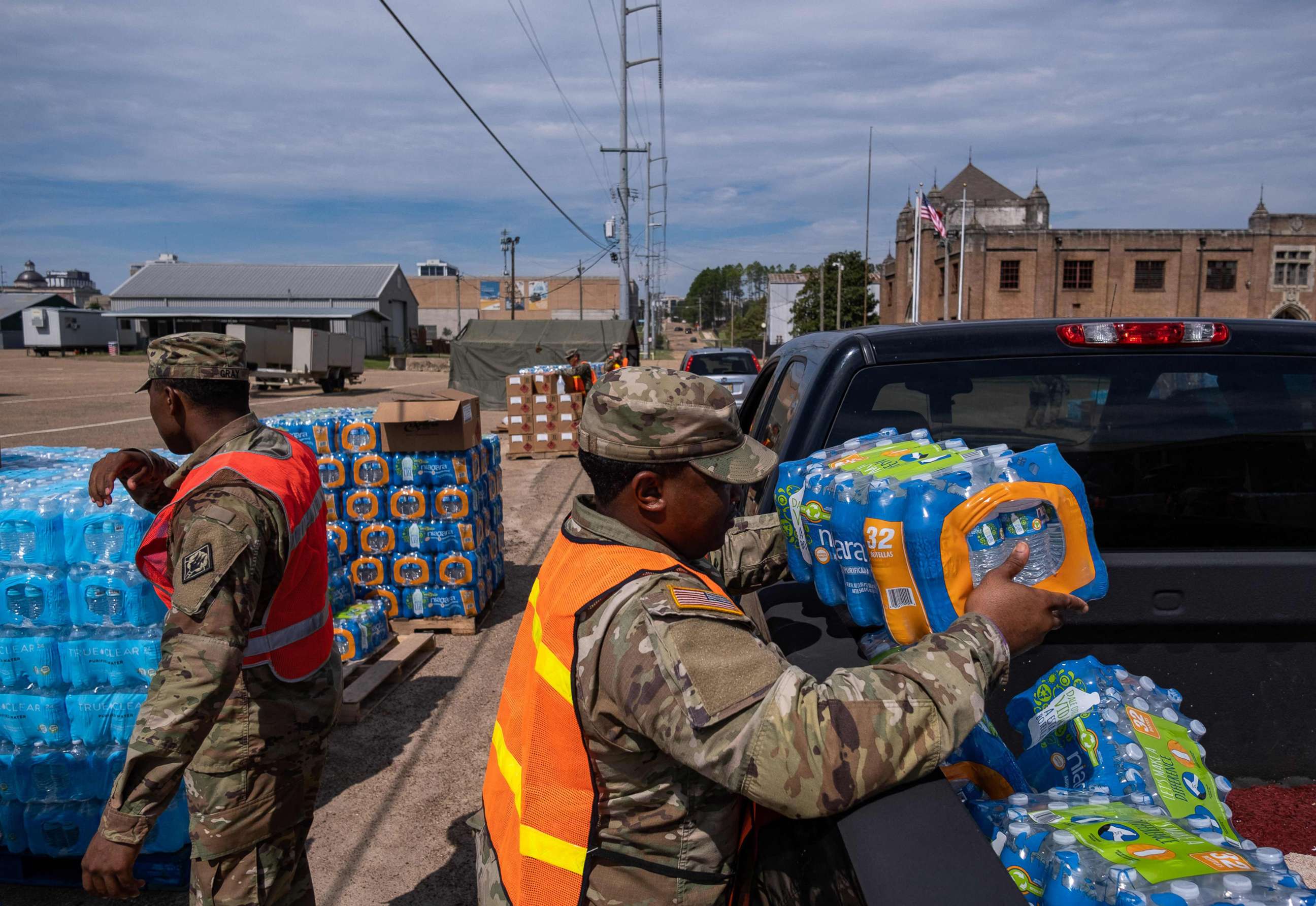 PHOTO: A member of the National Guard places a case of water in the back of a car at the State Fair Grounds in Jackson, Miss., Sept. 2, 2022. 