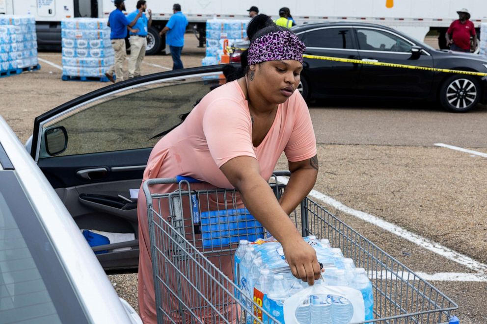 PHOTO: Jamiya Williams loads her car with two cases of bottled water at a Salvation Army of Jackson and Walmart distribution site at a Walmart, Aug. 31, 2022, in Jackson, Miss.