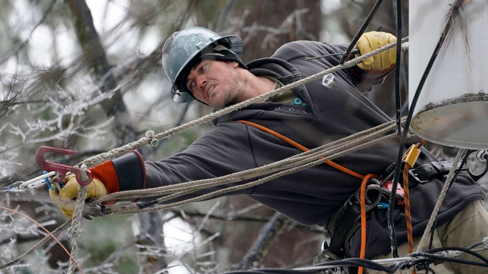 PHOTO: Lineman Sean Gregory stretches for a cable as he repairs a transformer in Jackson, Miss., Feb. 18, 2021.