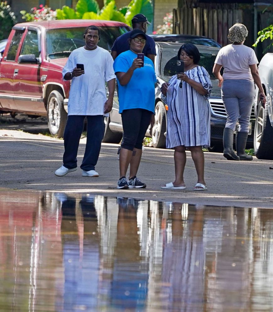 PHOTO: Residents record the rising floodwaters on their cellphones in a northeast Jackson, Miss., neighborhood, Aug. 28, 2022.
