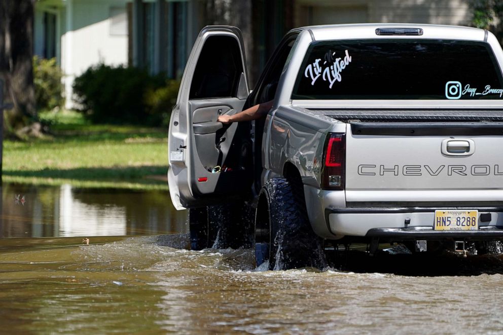 PHOTO: A homeowner keeps an eye on the floodwater's depth as he drives through a northeast Jackson, Miss., neighborhood, Aug. 28, 2022.