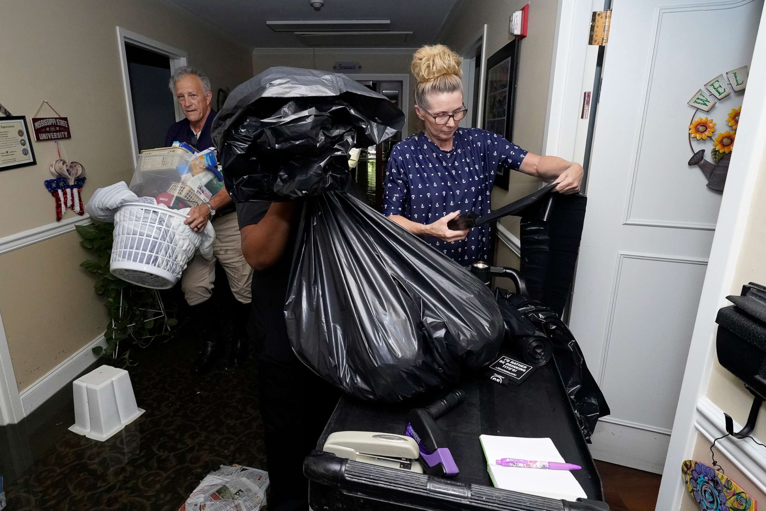 PHOTO: Residents, relatives and staff collect and carry out possessions from the flooded Peach Tree Village nursing home in Brandon, Miss., Aug. 24, 2022.