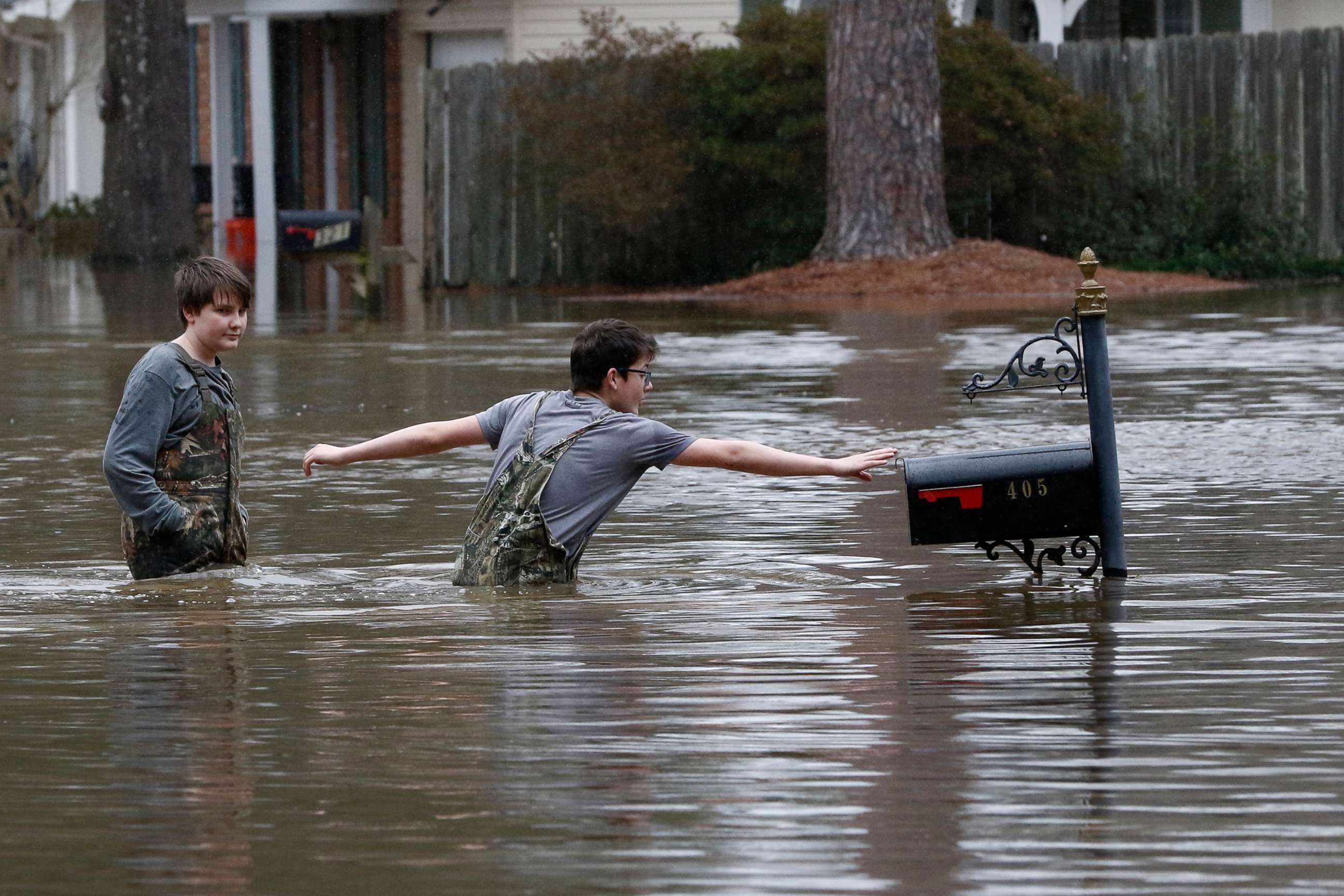 PHOTO: Blaine Henderson right, reaches to tag a mailbox as Pearl River as he and his friend Jonah Valdez play in the floodwaters of this northeast Jackson, Miss., neighborhood, Feb. 16, 2020.