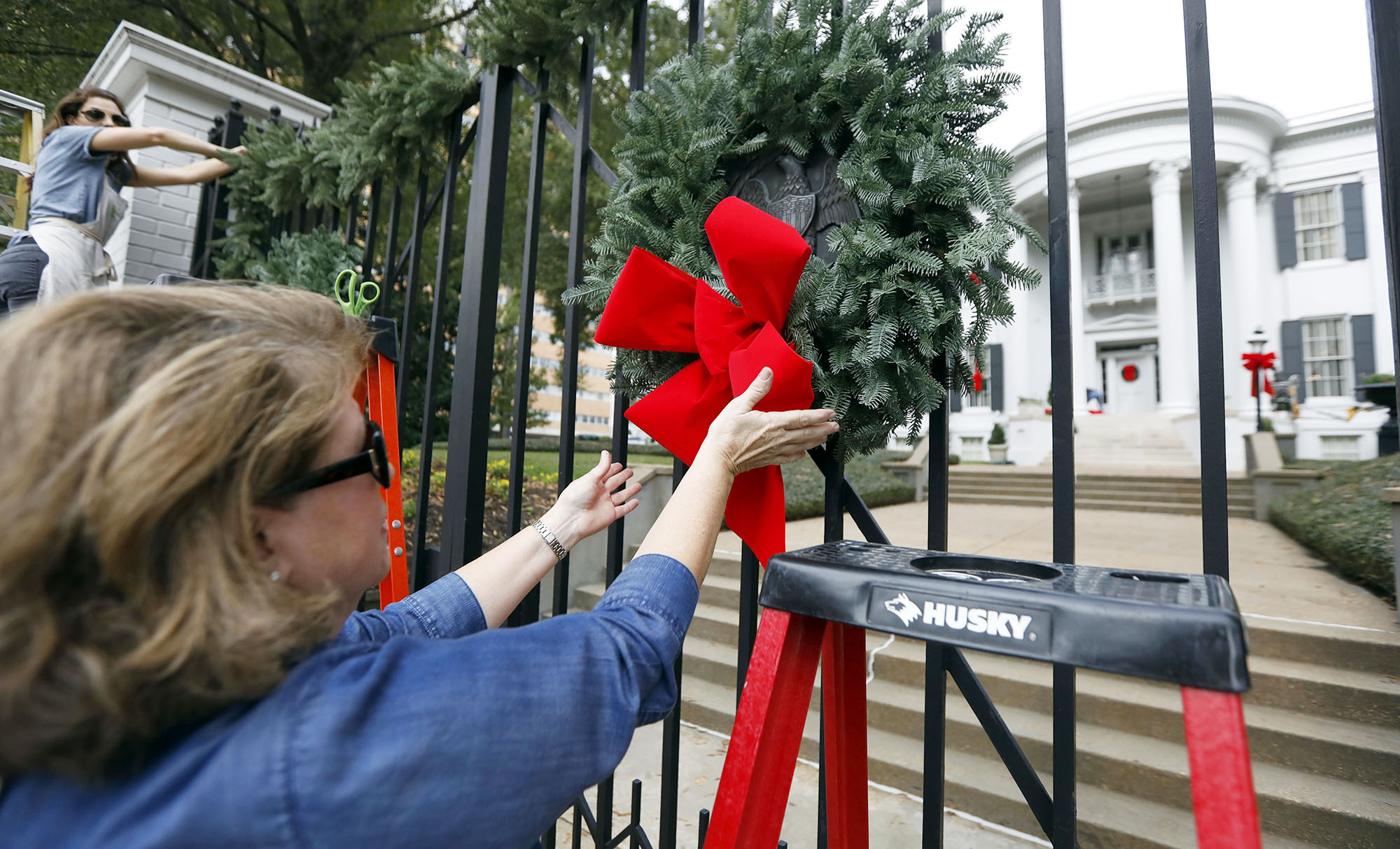 PHOTO: The bow on the holiday wreath in front of the Governor's Mansion is adjusted as  decorations are put in place in Jackson, Miss., Nov/ 15, 2017.