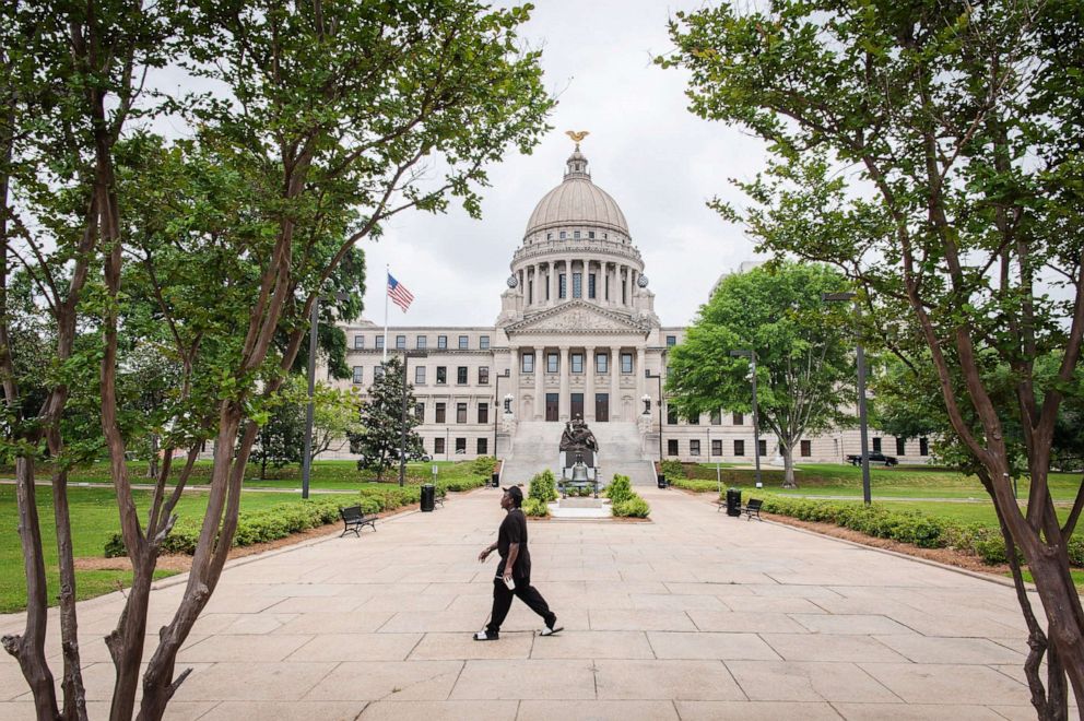 PHOTO: A pedestrian walks by the Mississippi State Capitol building in Jackson, Miss., April 8, 2020. 