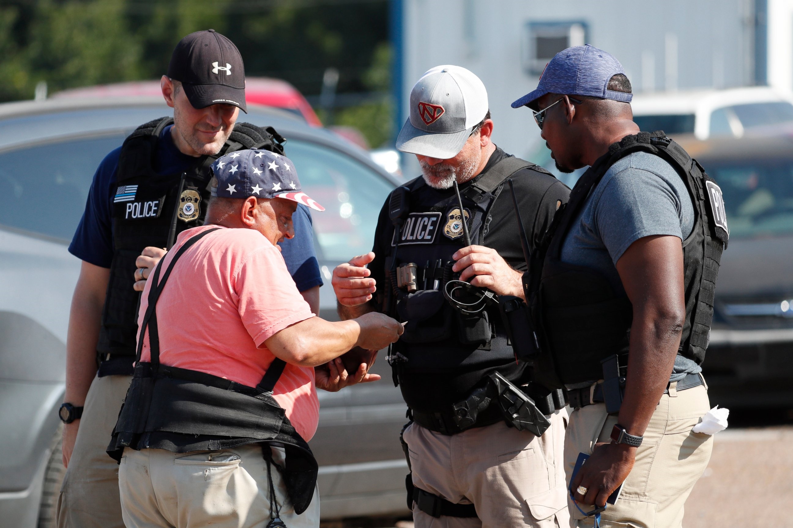 PHOTO: Domingo Candelaria, a registered immigrant, shows federal agents his identification as he prepares to leave the Koch Foods Inc., plant in Morton, Miss., following a raid by U.S. immigration officials, Wednesday, Aug. 7, 2019. 