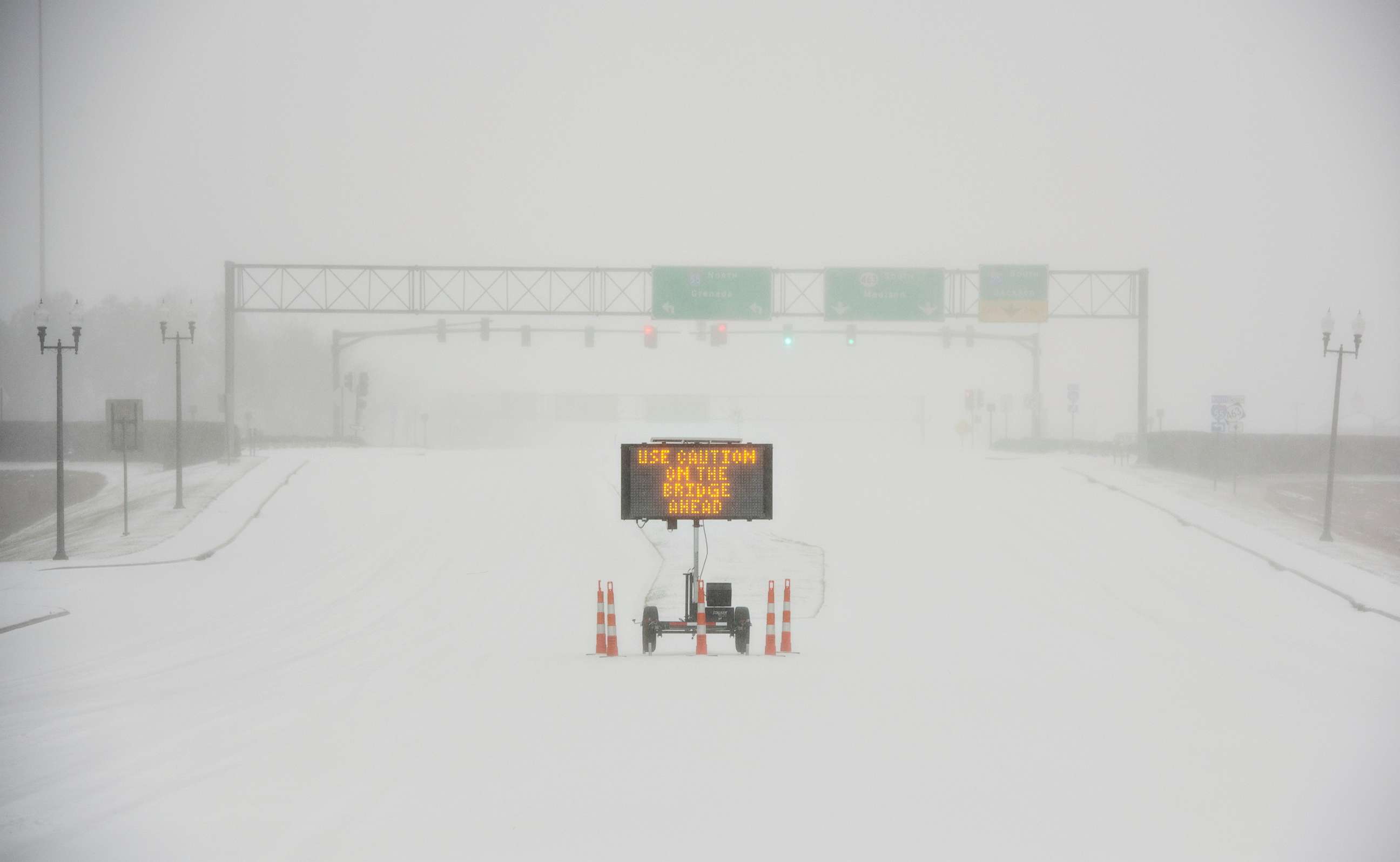PHOTO: A sign warns motorists after a sudden heavy bout of snow and frozen rain on MS Highway 463 in Madison, north of Jackson, Miss., Feb. 15, 2021.
