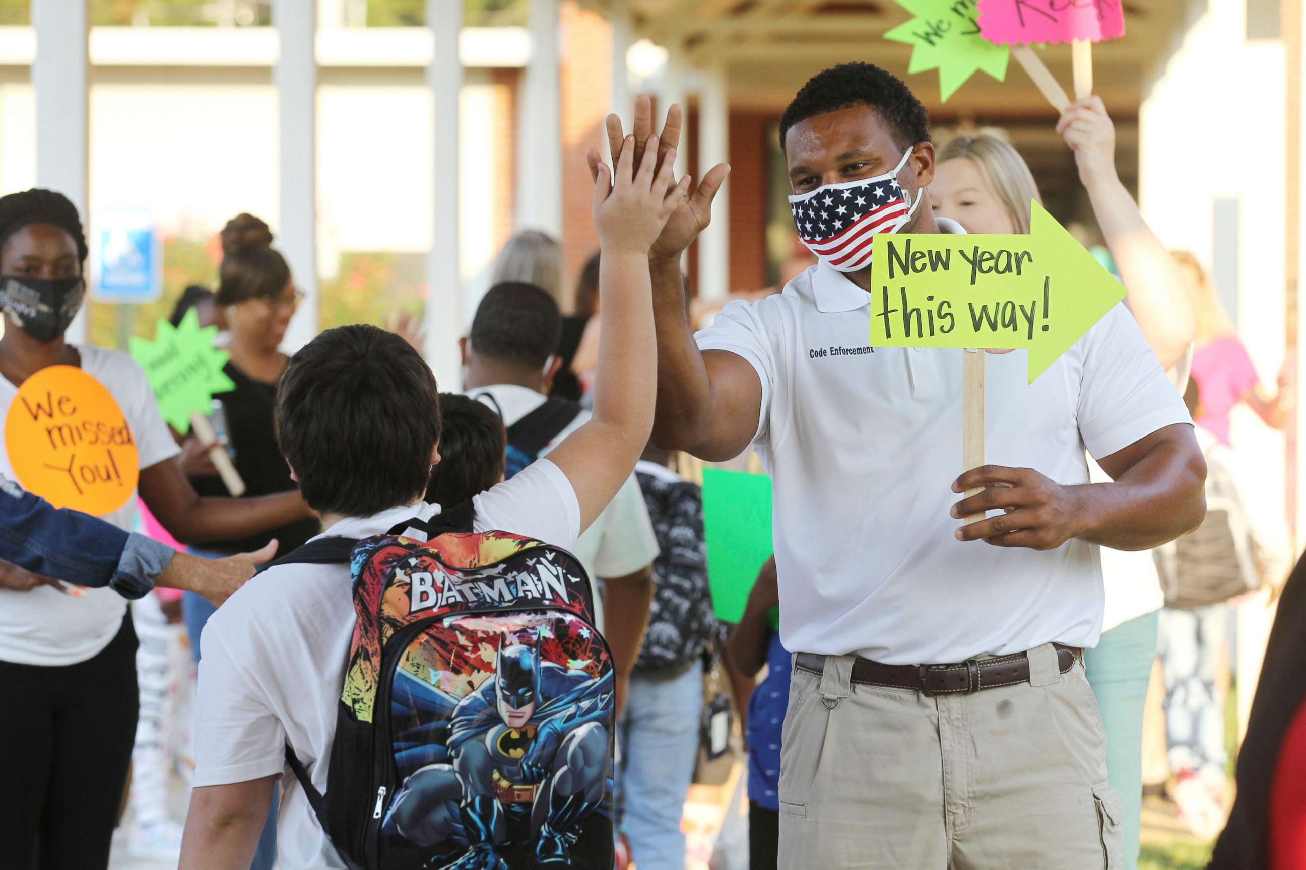 PHOTO: Shannon, Miss., Code Enforcement Officer Jeremandy Jackson gives a student a high five as parents, city officials, teachers and others welcome students back for the first day of school at Shannon Elementary School, Aug. 5, 2021.