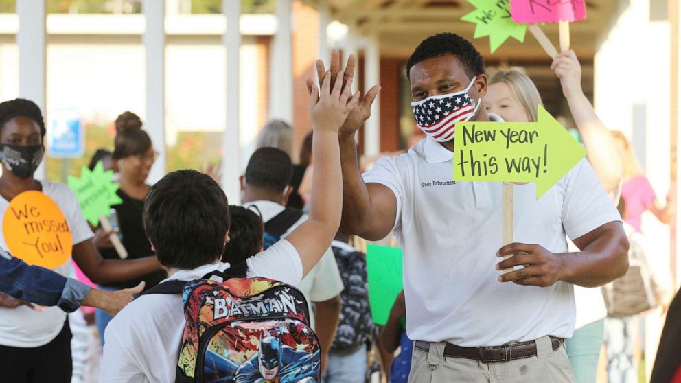 PHOTO: Shannon, Miss., Code Enforcement Officer Jeremandy Jackson gives a student a high five as parents, city officials, teachers and others welcome students back for the first day of school at Shannon Elementary School, Aug. 5, 2021.