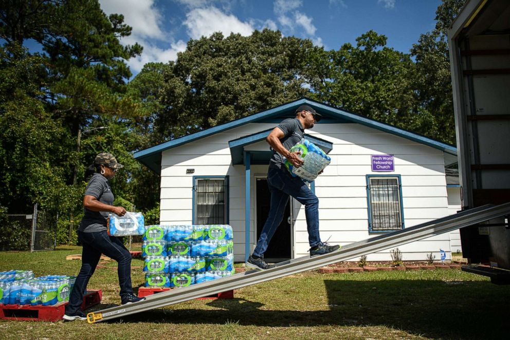 PHOTO: In this Sept. 15, 2022, file photo, Bishop Phillip Marks, right, and his wife, Tenae Marks, work on loading bottled water onto a truck at Fresh Word Fellowship Church in Fayetteville, N.C.