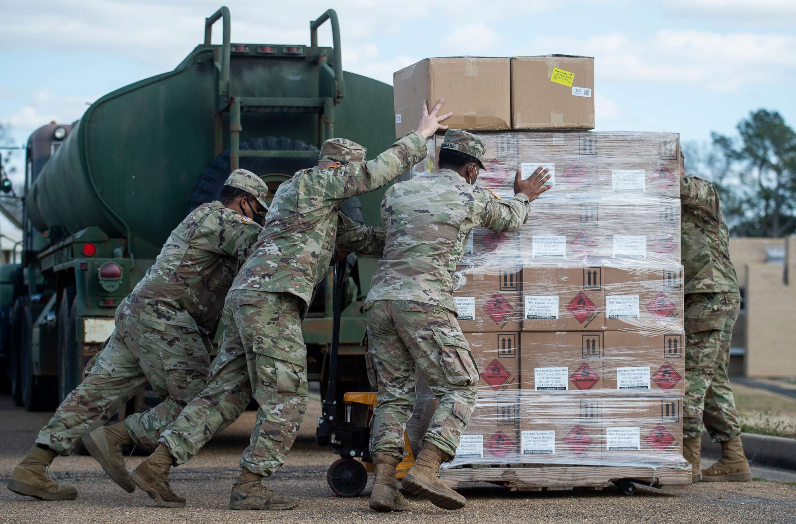 PHOTO: Mississippi National Guard soldiers put hand sanitizer and masks in place for residents in Jackson, Miss., Feb. 24, 2021. The soldiers also distributed non-potable water to residents due to a water outage after last week's winter storms.
