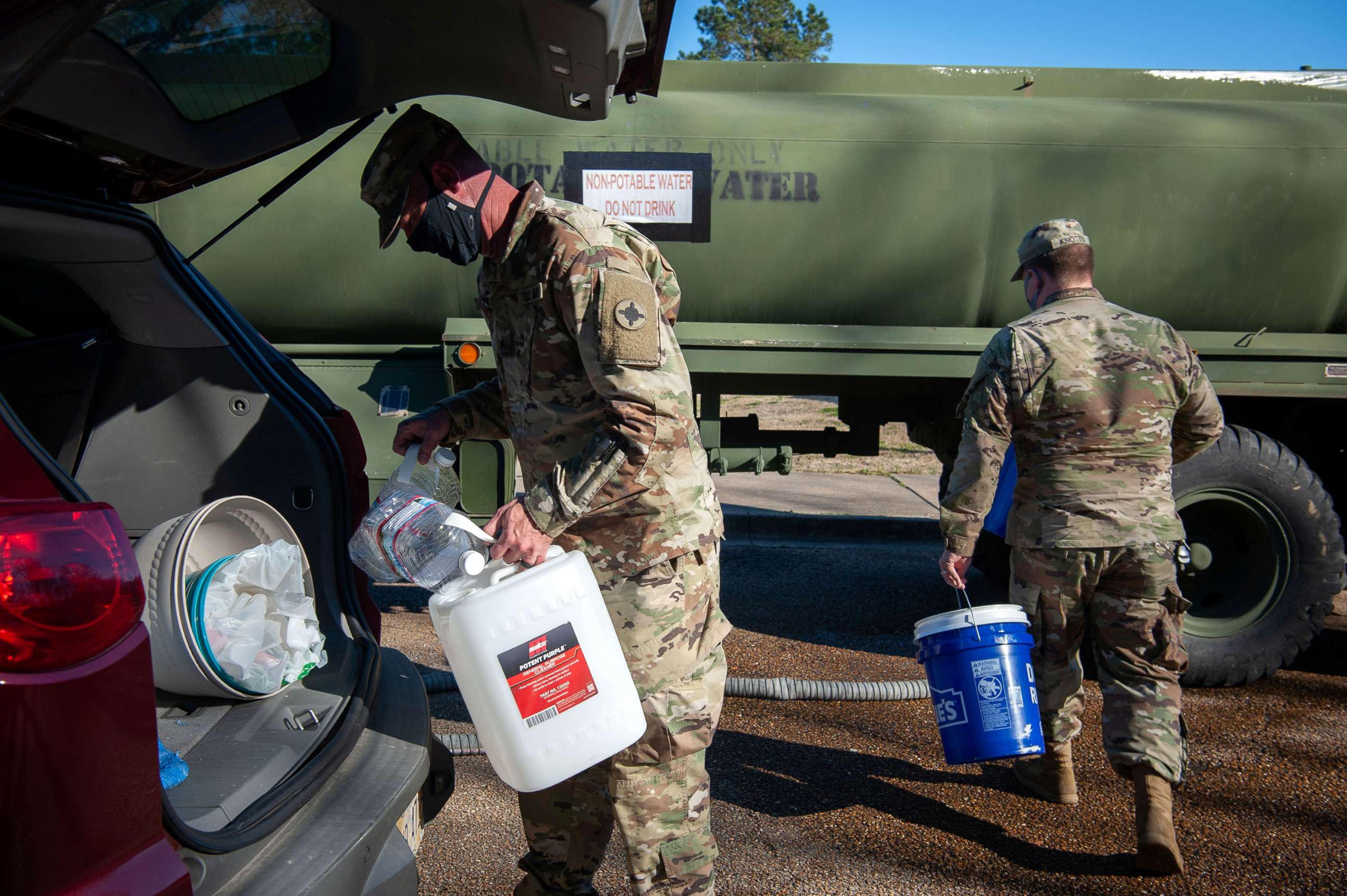 PHOTO: National Guard sergeants fill with water for residents at a public water distribution site after a recent bout of cold weather caused large numbers of water outages, some going into their third week, in Jackson, Miss., March 4, 2021.
