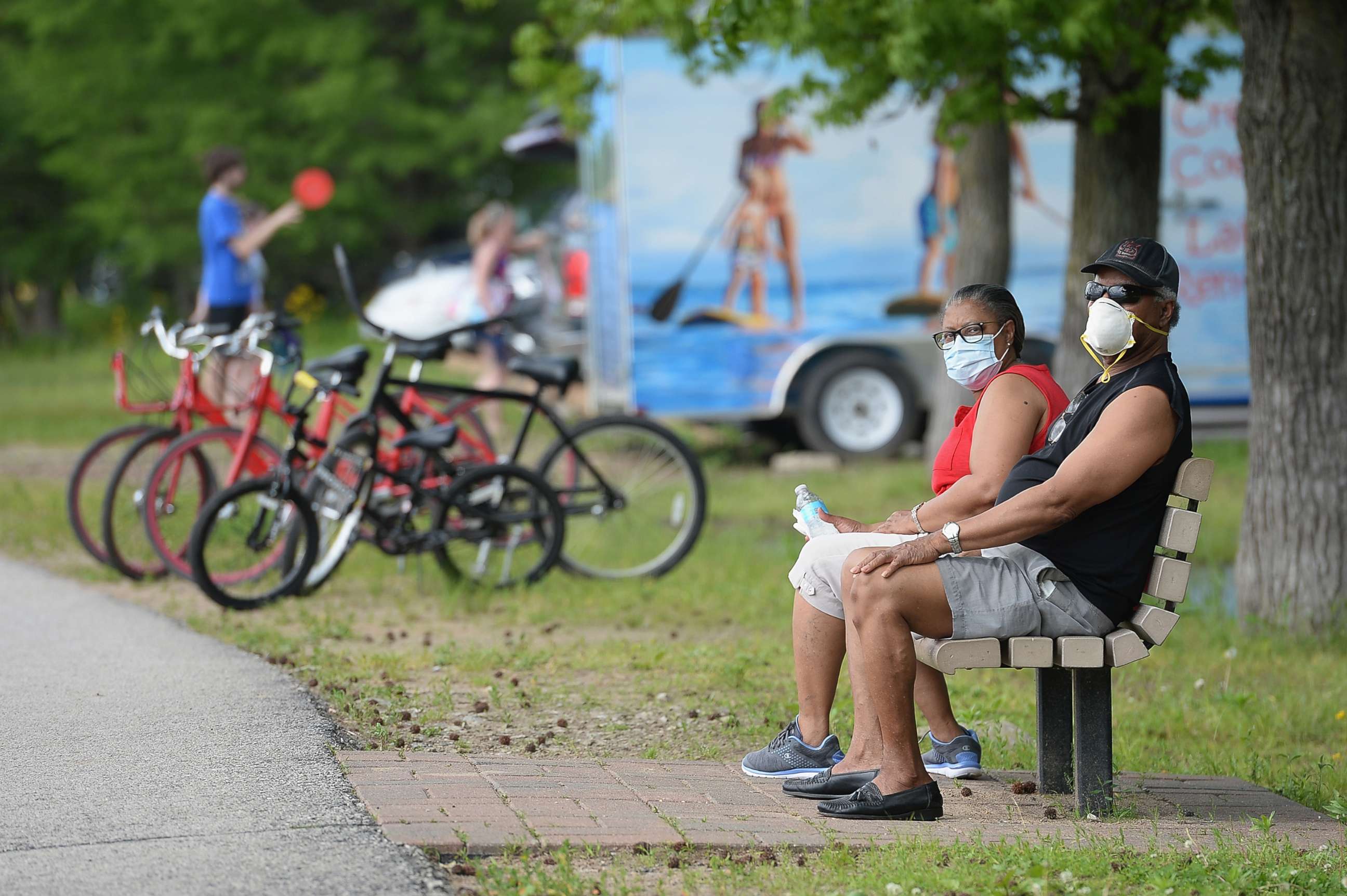 PHOTO: A man and woman sit with their masks on at Creve Coeur Lake Park on May 25, 2020 in Maryland Heights, Missouri.