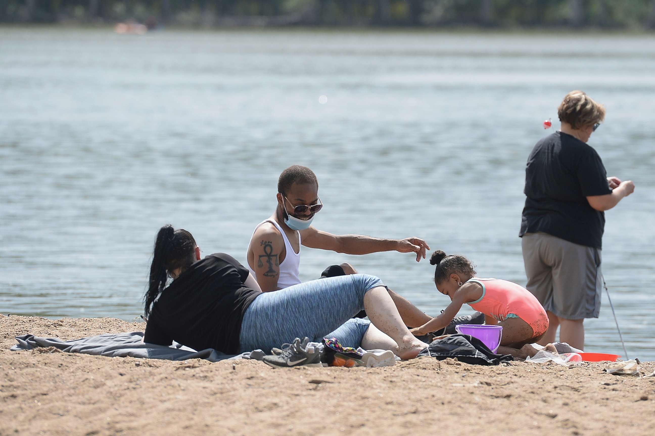 PHOTO: A family spends Memorial Day relaxing on a beach front at Creve Coeur Lake Park on May 25, 2020 in Maryland Heights, Missouri.