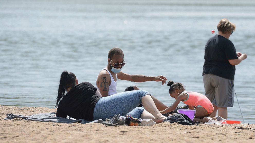 PHOTO: A family spends Memorial Day relaxing on a beach front at Creve Coeur Lake Park on May 25, 2020 in Maryland Heights, Missouri.