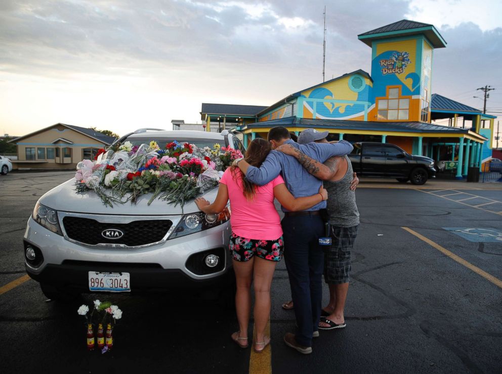 PHOTO: People pray by a car thought to belong to a victim of Thursday's boating accident before a candlelight vigil in the parking lot of Ride the Ducks, July 20, 2018, in Branson, Mo.