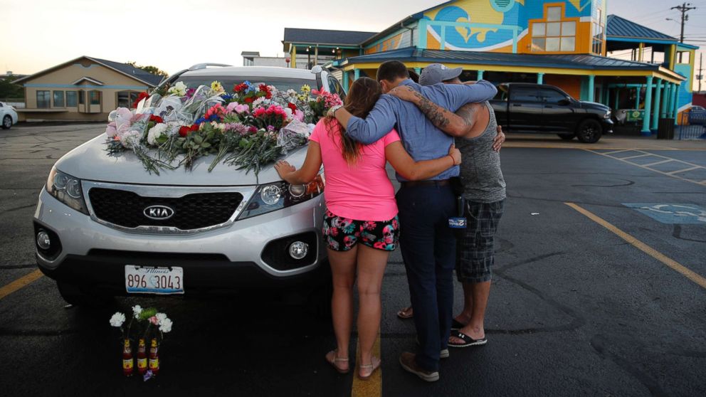 PHOTO: People pray by a car thought to belong to a victim of Thursday's boating accident before a candlelight vigil in the parking lot of Ride the Ducks, July 20, 2018, in Branson, Mo.