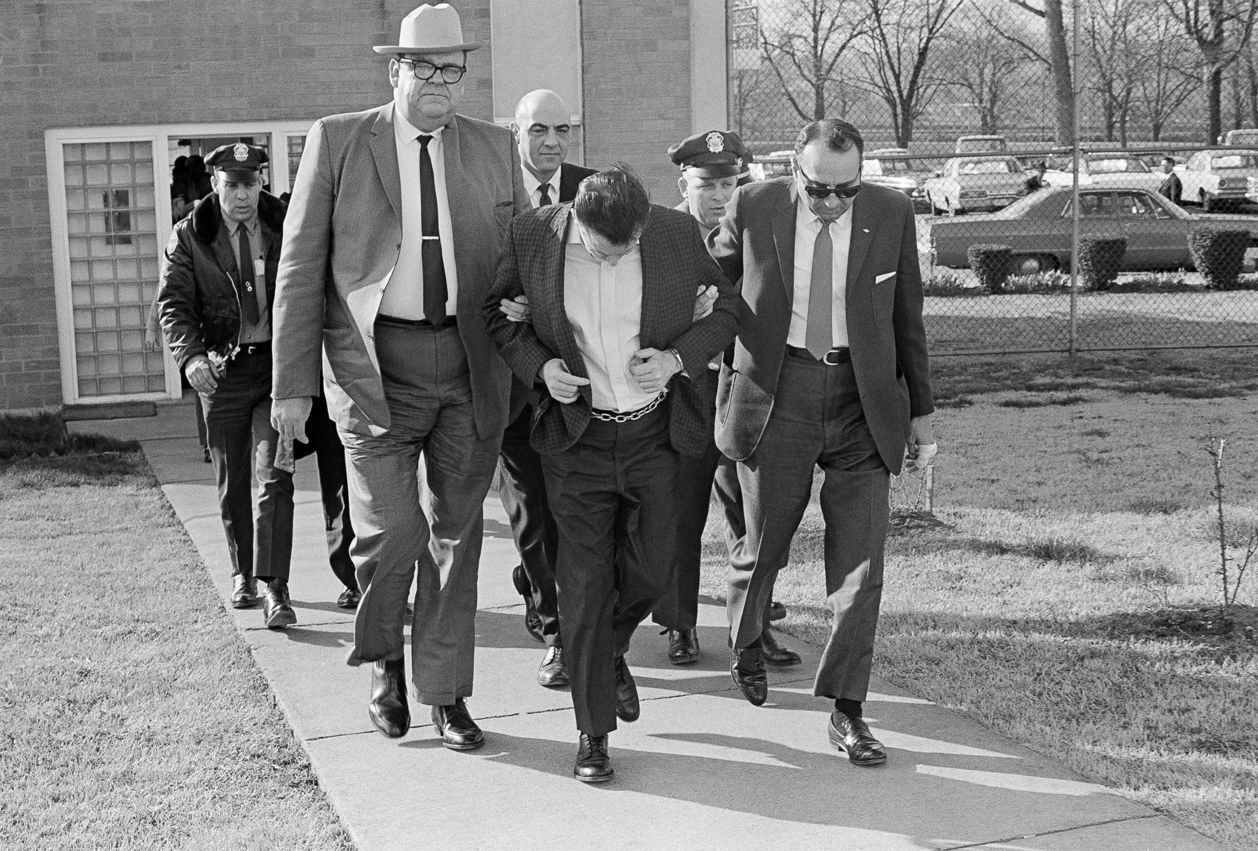 PHOTO: James Earl Ray lowers his head as State Safety commissioner Greg O'Rear, white hat, and Highway Patrol Maj. Mickey McGuire, dark glasses, lead him to prison in Nashville, Tenn., March 11, 1969.  