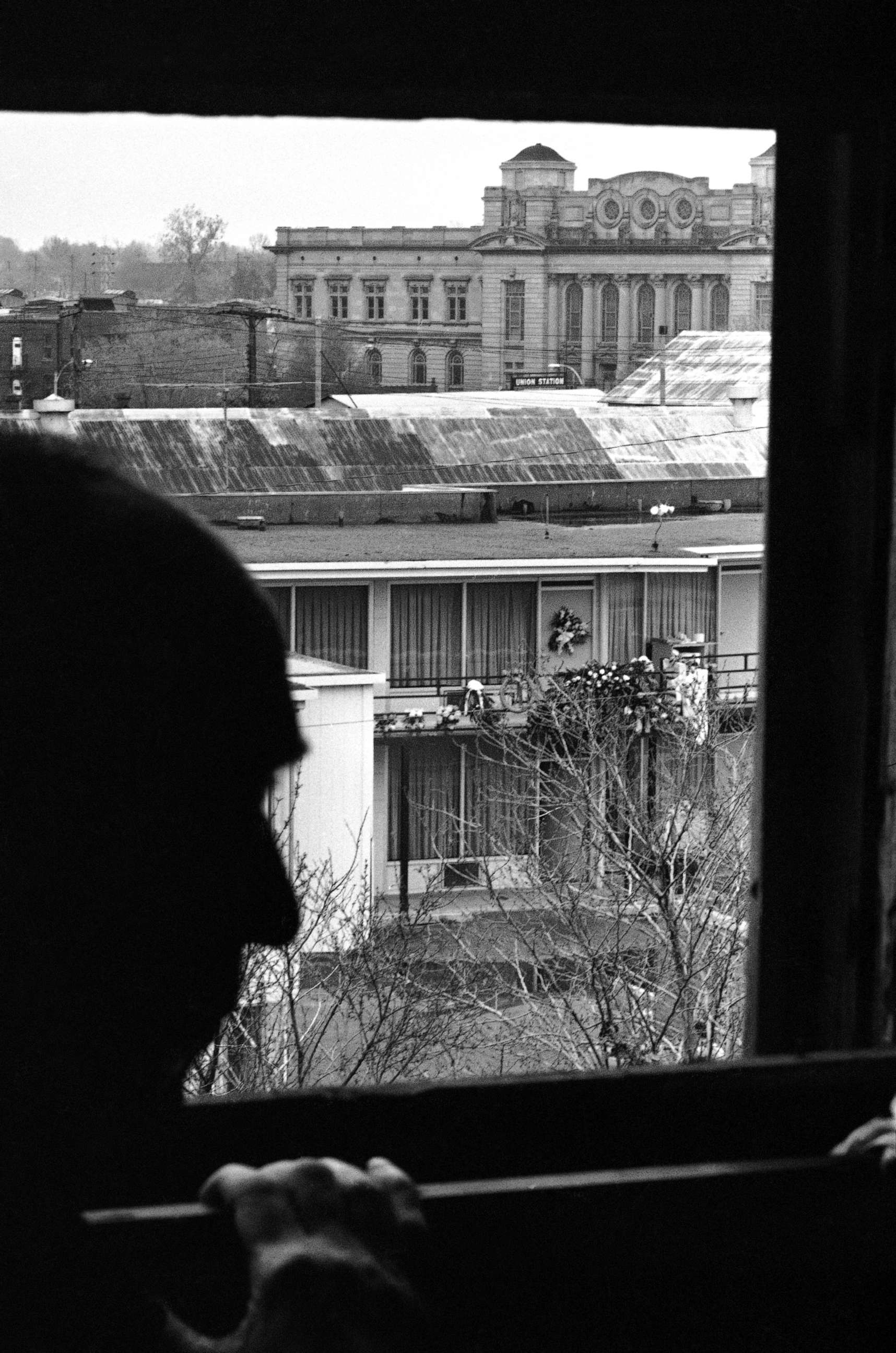 PHOTO: Charles Q. Stephens looks across the street to the Lorraine Motel, April 9, 1968, where flowers mark the spot that Martin Luther King Jr. was assassinated in Memphis, Tenn. This view, from the rooming house, is where the shoot took place.