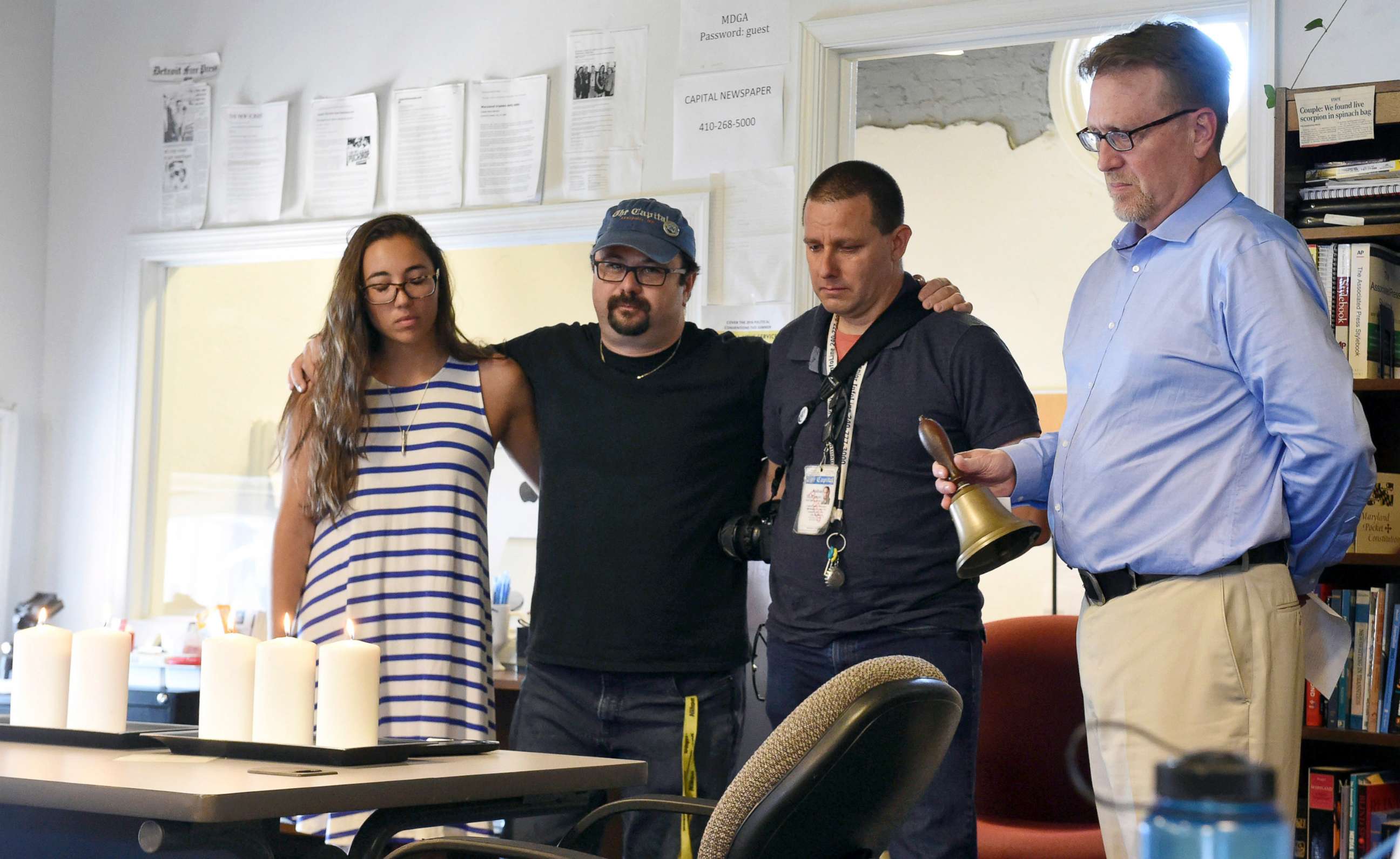 PHOTO: Rick Hutzell, right, the editor for Capital Gazette, from left, reporter Selene San Felice, and photojournalists Paul W. Gillespie and Joshua McKerrow, as he rings a bell during a moment of silence at 2:33 p.m., July 5, 2018, in Annapolis, Md..