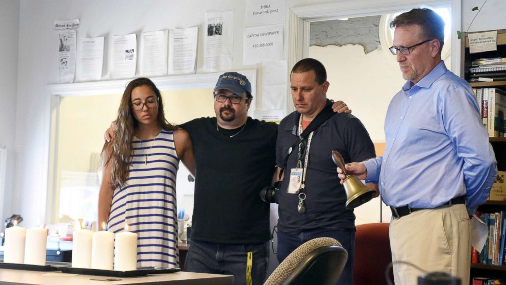 PHOTO: Rick Hutzell, right, the editor for Capital Gazette, from left, reporter Selene San Felice, and photojournalists Paul W. Gillespie and Joshua McKerrow, as he rings a bell during a moment of silence at 2:33 p.m., July 5, 2018, in Annapolis, Md..