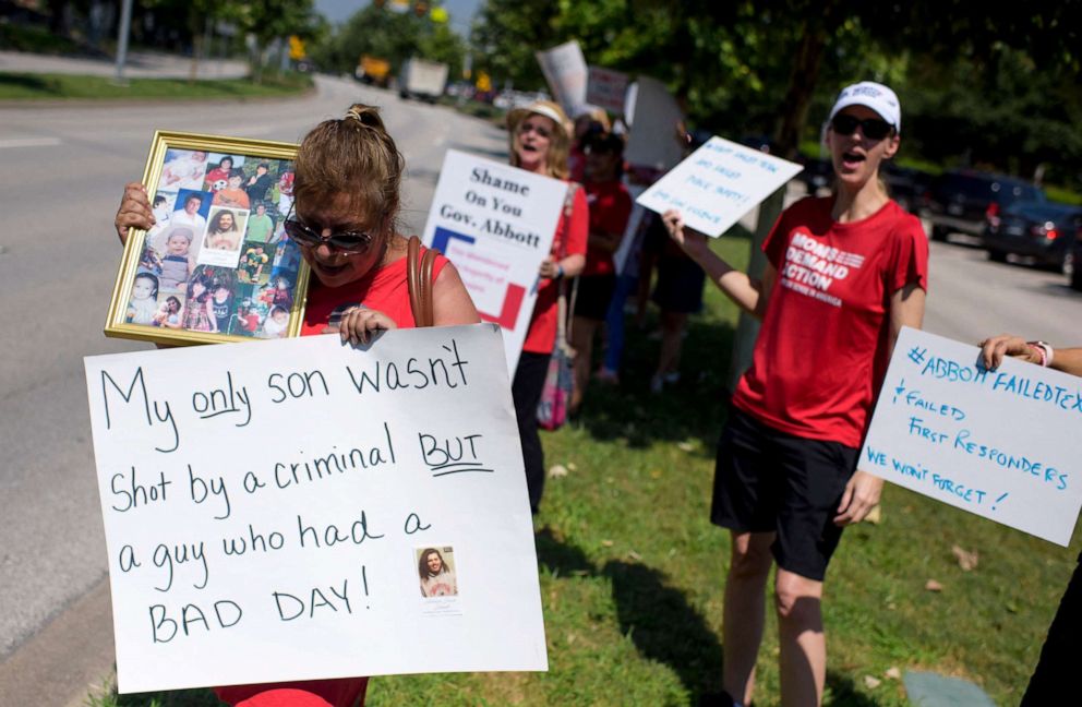 PHOTO: People hold signs during a "Moms Demand Action" protest in response to a new Texas gun law at Buffalo Bayou Park in Houston, Texas on June 17, 2021.