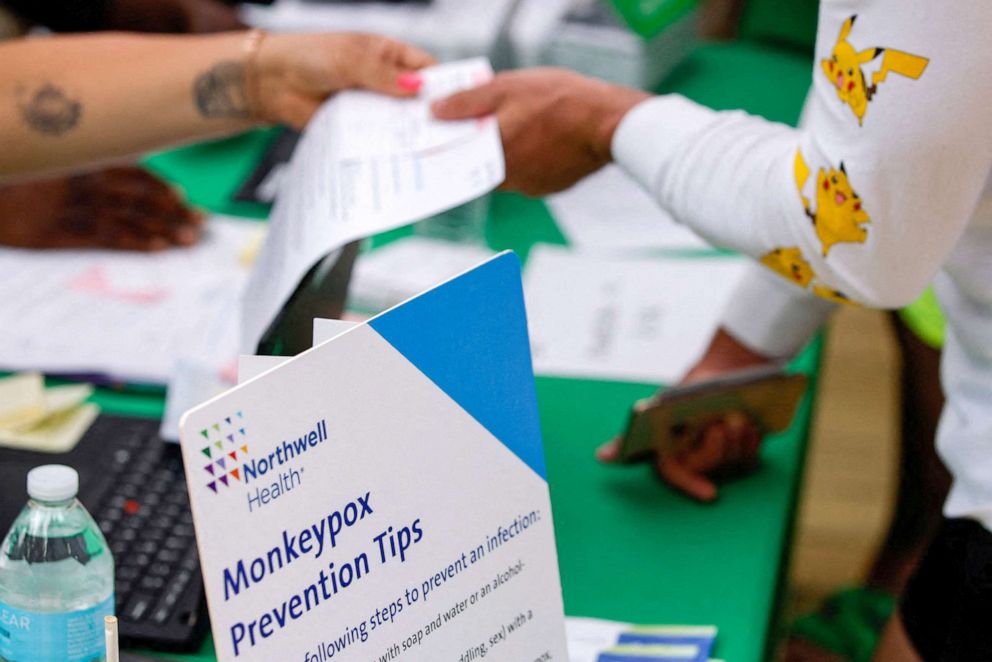 PHOTO: A sign lists monkeypox prevention tips, next to a person arriving to receive a monkeypox vaccination at the Northwell Health Immediate Care Center, in New York, July 15, 2022. 