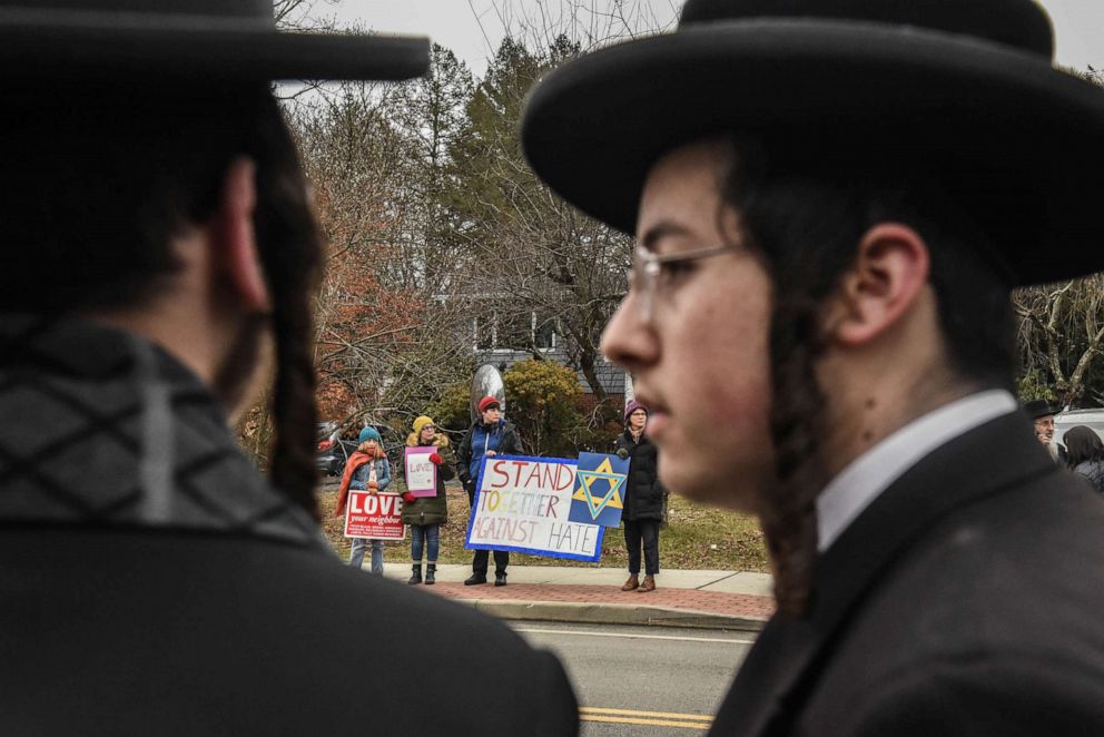 PHOTO: People hold signs of support near the house of Rabbi Chaim Rottenberg on Dec. 29, 2019, in Monsey, New York.