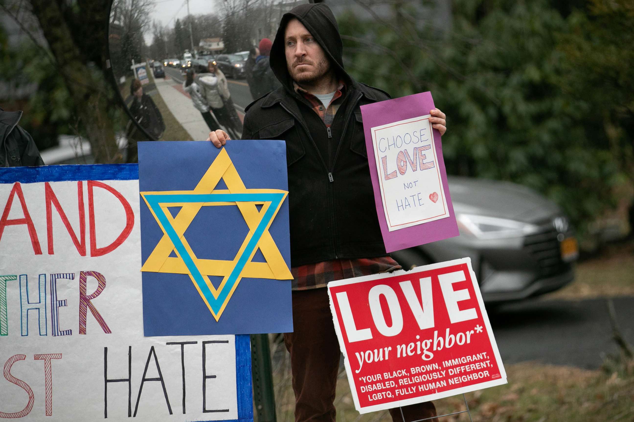 PHOTO: A man holds a sign outside the home of rabbi Chaim Rottenberg in Monsey, New York, Dec. 29, 2019.