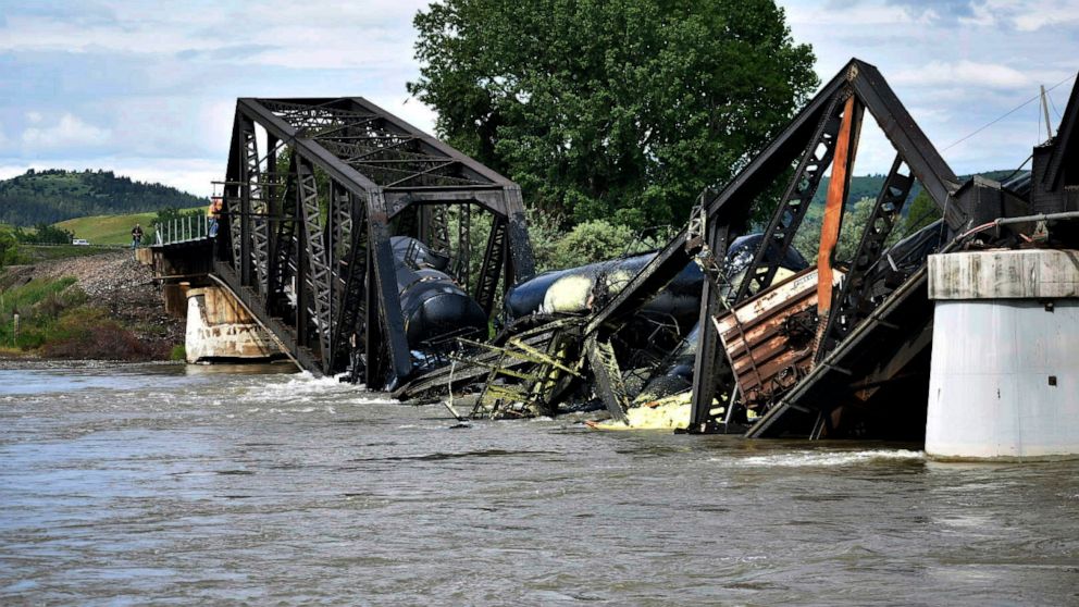 PHOTO: Several train cars are immersed in the Yellowstone River after a bridge collapse near Columbus, Mont., on June 24, 2023. The bridge collapsed overnight, causing a train that was traveling over it to plunge into the water below.