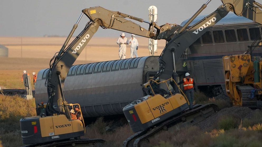 PHOTO: Workers stand on an overturned train car as front-loaders prop up another train car, Sept. 26, 2021, just west of Joplin, Mont.