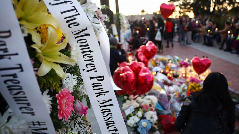 PHOTO: A message dedicated to victims, which is attached to a floral arrangement, is seen before the start of a candlelight vigil for victims of a deadly mass shooting at a ballroom dance studio on Jan. 24, 2023 in Monterey Park, California.