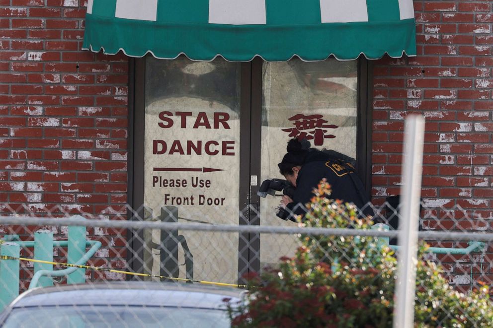 PHOTO: A person from the crime lab takes photographs around the rear entrance of the location of a shooting that took place during a Chinese Lunar New Year celebration, in Monterey Park, Calif., Jan. 22, 2023.