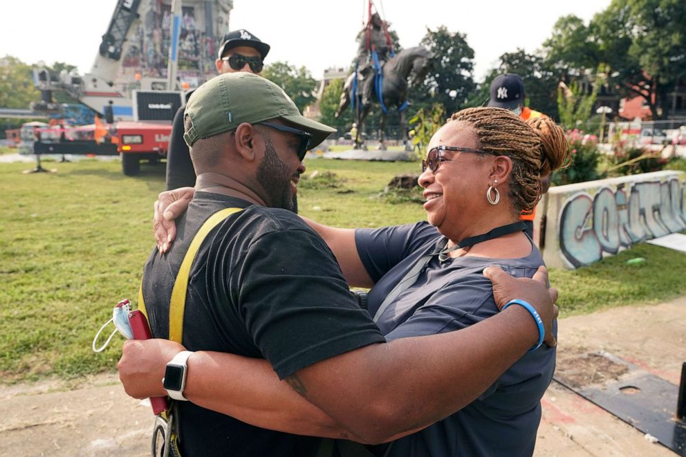 PHOTO: Devon Henry, owner of the construction company that removed the statue, hugs his mom, Freda Thornton, after he removed one of the country's largest remaining monuments to the Confederacy, in Richmond, Va., Sept. 8, 2021.