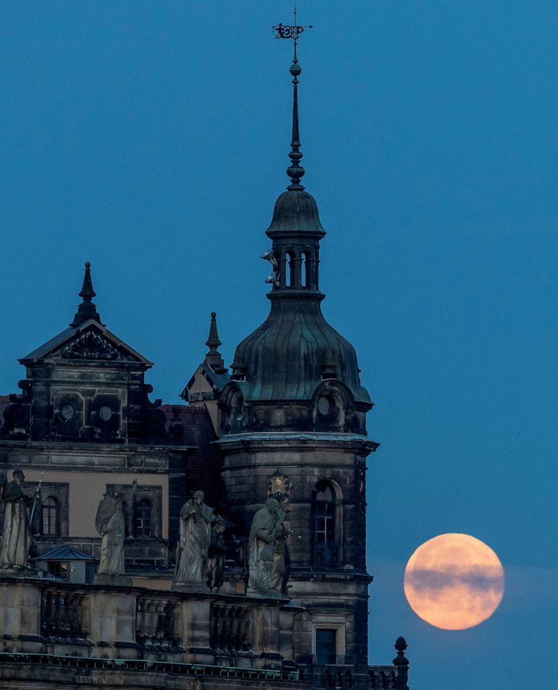 PHOTO: A full moon sets behind the old town district in Dresden, Germany, June 15, 2022.