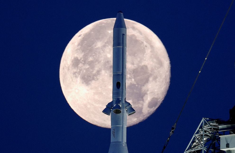 PHOTO: A full moon is shown with the top of NASA's next-generation moon rocket, the Space Launch System (SLS) Artemis 1, at the Kennedy Space Center in Cape Canaveral, Fla., June 15, 2022.
