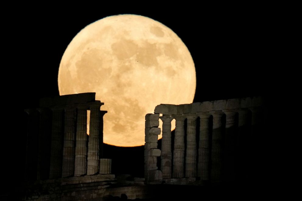 PHOTO: A full moon rises behind the ancient temple of Poseidon at Cape Sounion, south of Athens, Greece, June 14, 2022.