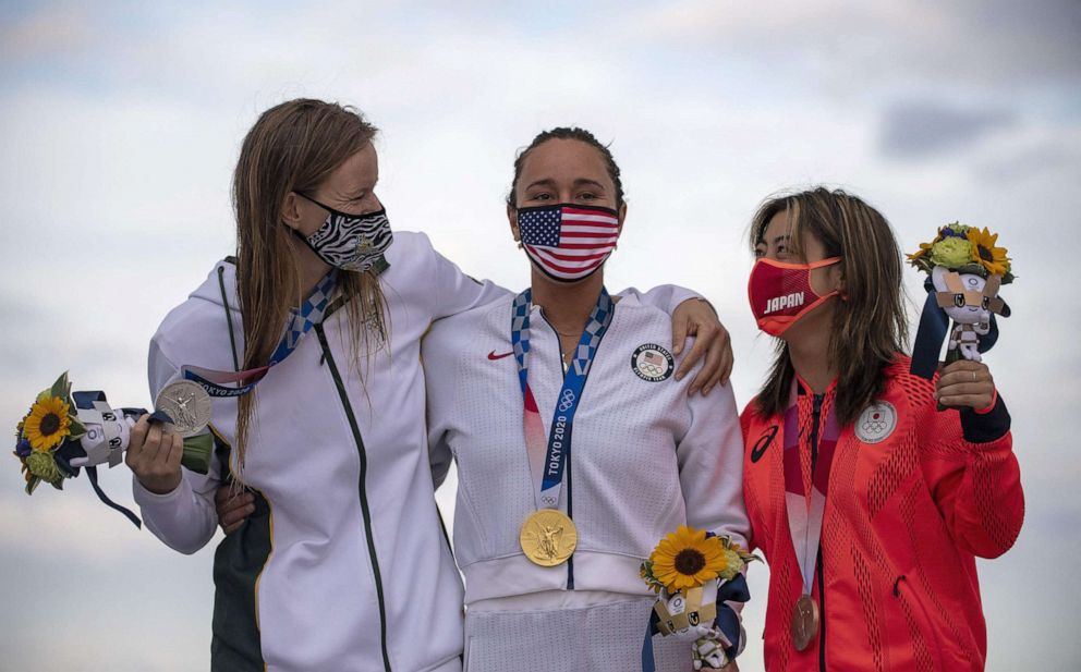 PHOTO: USA's Carissa Moore, center, Gold medalist, South Africa's Bianca Buitendag, left, Silver medalist and Japan's Amuro Tsuzuki, celebrate on the podium at the Tsurigasaki Surfing Beach, in Chiba, on July 27, 2021 during the Tokyo 2020 Olympic Games.