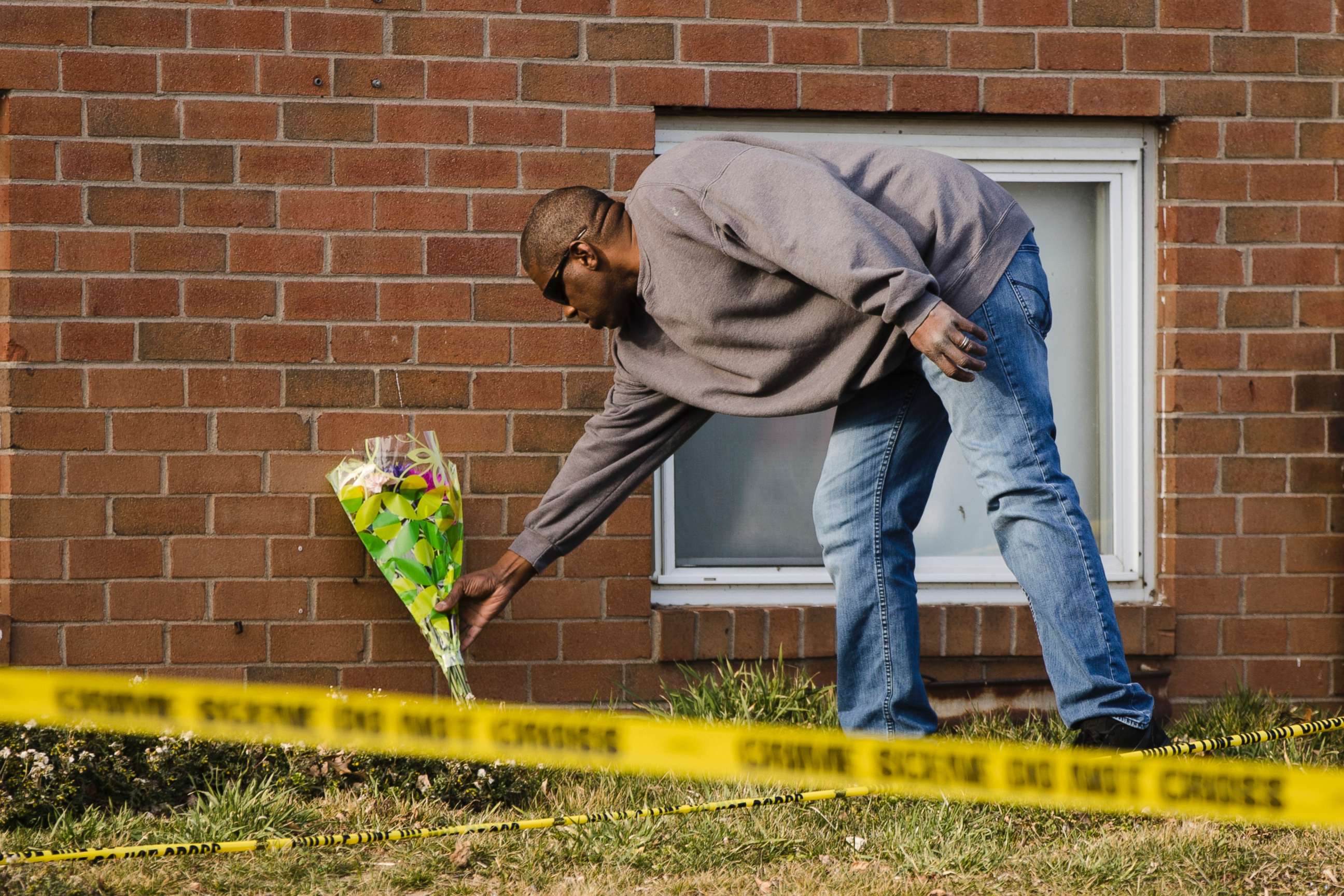 PHOTO: A man places flowers at the Robert Morris Apartments in Morrisville, Pa., Feb. 26, 2019.