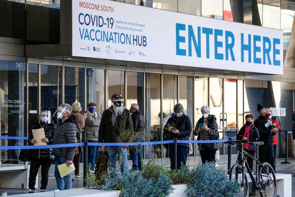 PHOTO: People stand in line at the mass vaccination site at San Francisco's Moscone Convention Center, on opening day, for healthcare workers and people over 65 on Feb. 5, 2021, in San Francisco.