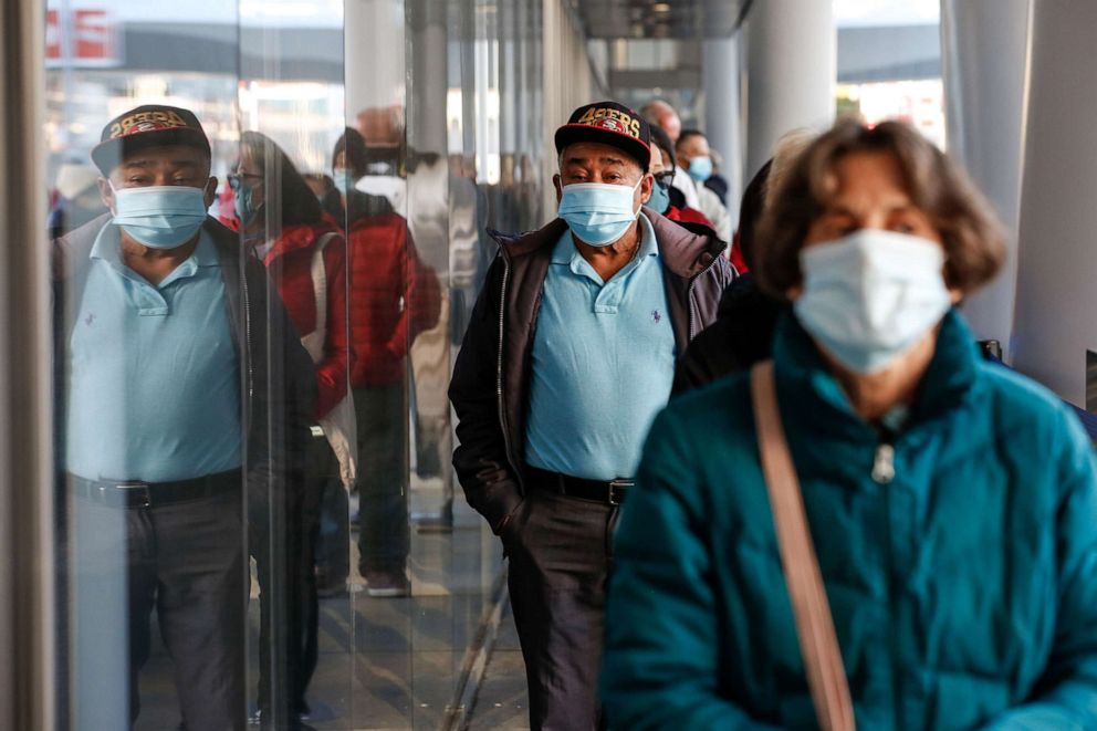 PHOTO: People stand in line at the mass vaccination site at San Francisco's Moscone Convention Center, on opening day, on Feb. 5, 2021, in San Francisco.