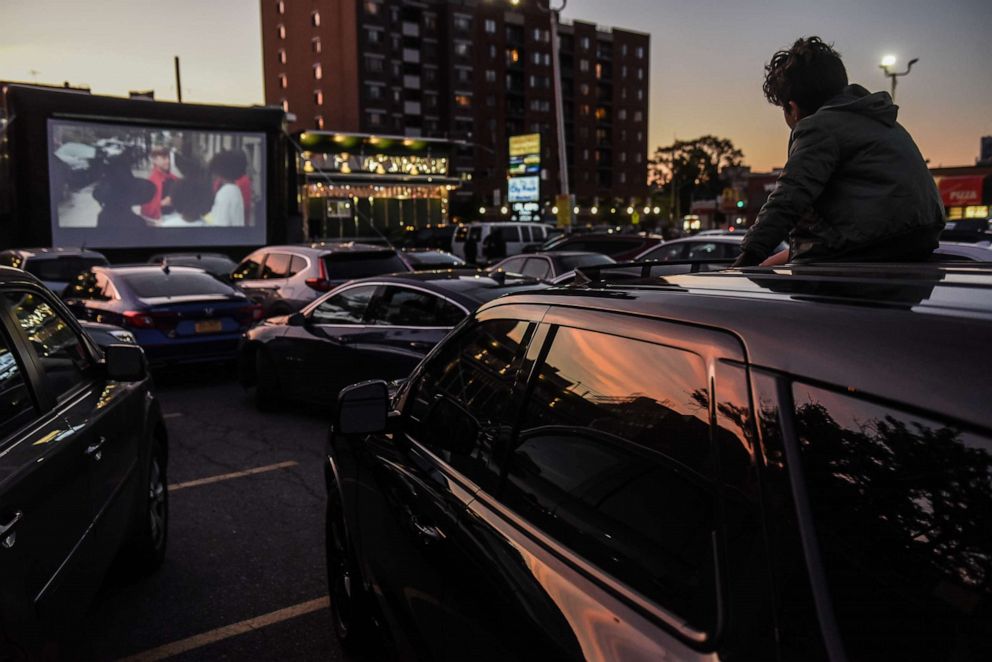 PHOTO: A child watches a movie from the sunroof of a car during a screening of a drive-in movie at the Bel Aire diner on May 20, 2020 in the Astoria neighborhood in the Queens borough in New York.