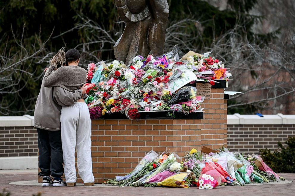 PHOTO: Michigan State University juniors Morgan Wright, left, and Ava Van Vleck embrace as they reflect at the Sparty statue, Feb. 14, 2023, on the MSU campus in East Lansing a day after a shooting at the university.