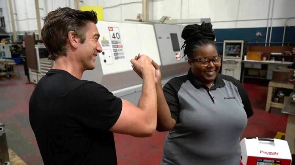 PHOTO: "World News Tonight" anchor David Muir high fives Igloo Coolers e-commerce manager Anqunette Lewis at the Igloo Coolers factory in Katy, Texas.