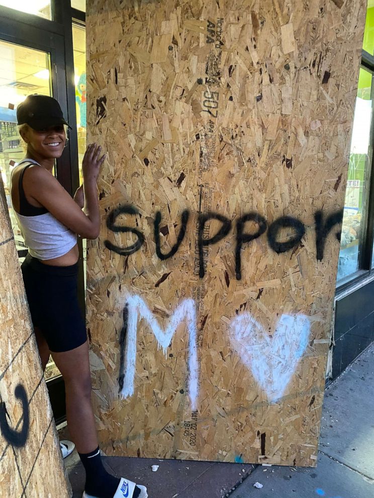 PHOTO: Minneapolis activist Kenda Zellner-Smith picks up plywood boards with Black Lives Matter art as part of her effort to preserve the boards.